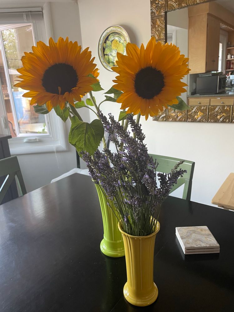 The vases with lavender and sunflowers. Two sunflowers are turned toward the camera, resembling eyes. 
