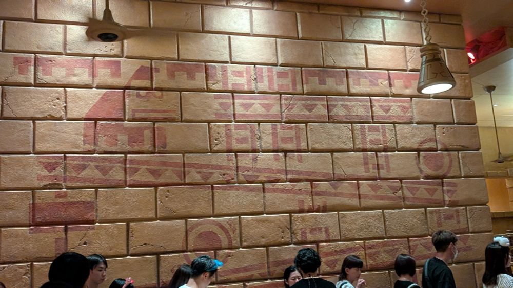 An artistic representation of a level from the original Mario Bros. game features Donkey Kong on a downward-sloping incline, a barrel rolling down it. 