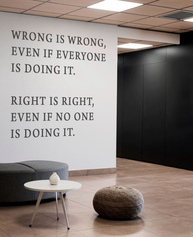 An image of an office wall with ‘wrong is wrong even if everyone is doing it. Right is right even if no one is doing it’ written on it