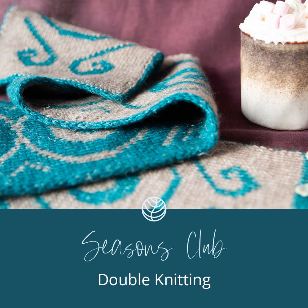 Two-colour double knitting project lying in a table with a mug of hot chocolate next to it with the words “Seasons Club Double Knitting” below.