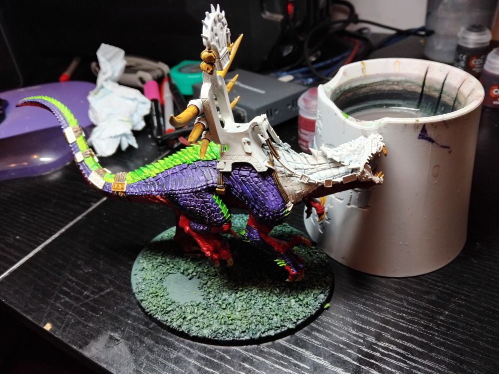 A Seraphon Carnosaur half painted in Contrast red purple and green. Just stuck to base. 