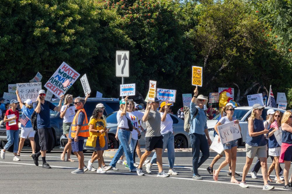 People protesting at the No Kings protest in Dana Point, California, on October 18, 2025
