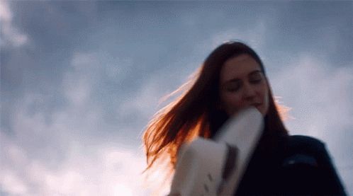 Nicole Haught placing her Stetson hat on her head, hair blowing in the wind