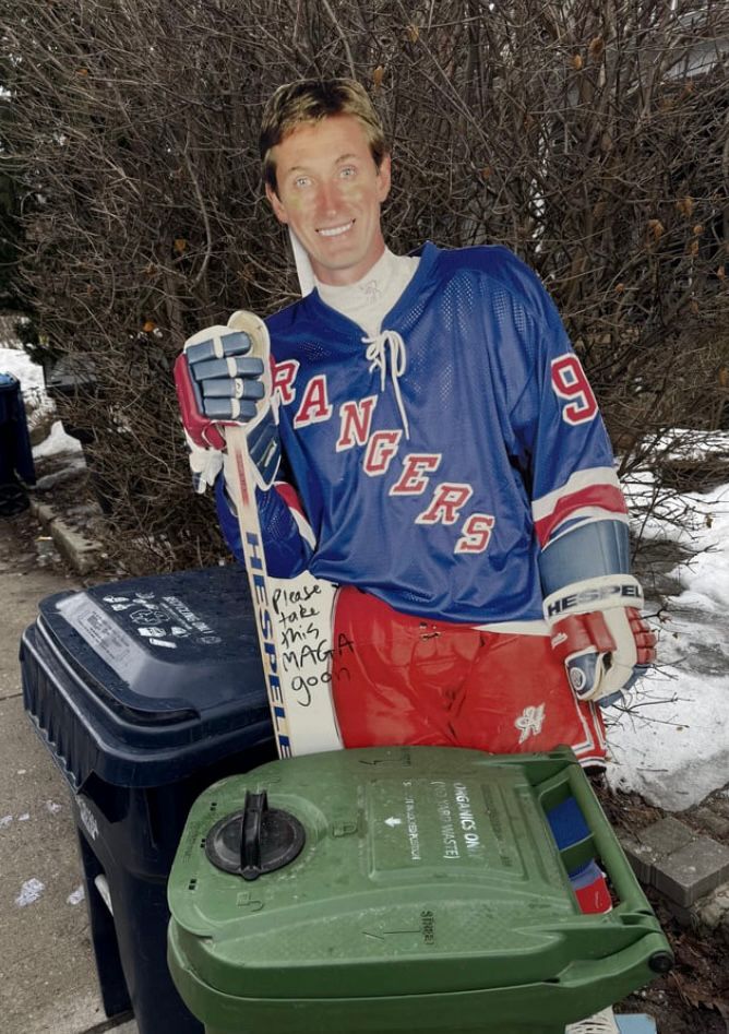 Cardboard cutout of Wayne Gretzky put out with the trash with the words Please take this maga goon written on it 