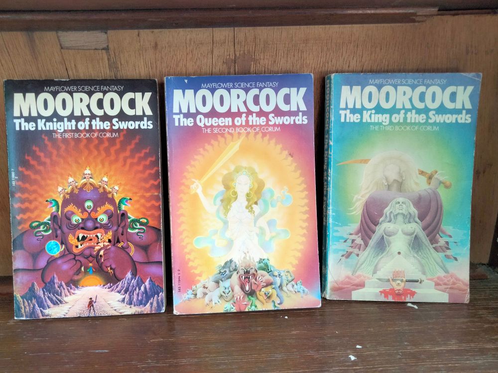 Three paperback novels in Michael Moorcock's "Corum trilogy". They have lovely psychedelic artwork depicting wrathful demonic gods