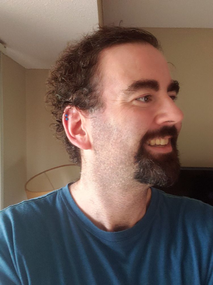 Selfie showing off double helix piercing in right ear