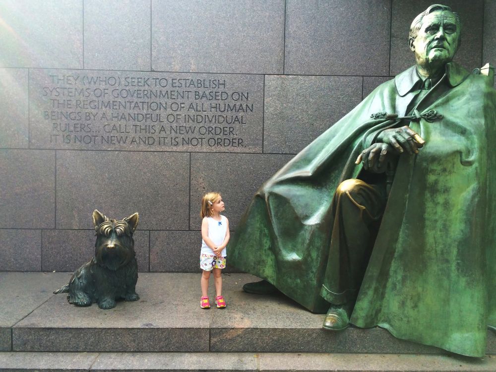 A large statue of FDR and his dog, Fala, with a little girl showing how big the dog is.