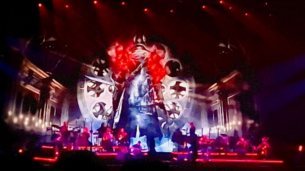 Bloodborne hunter graphic behind an orchestra on stage.