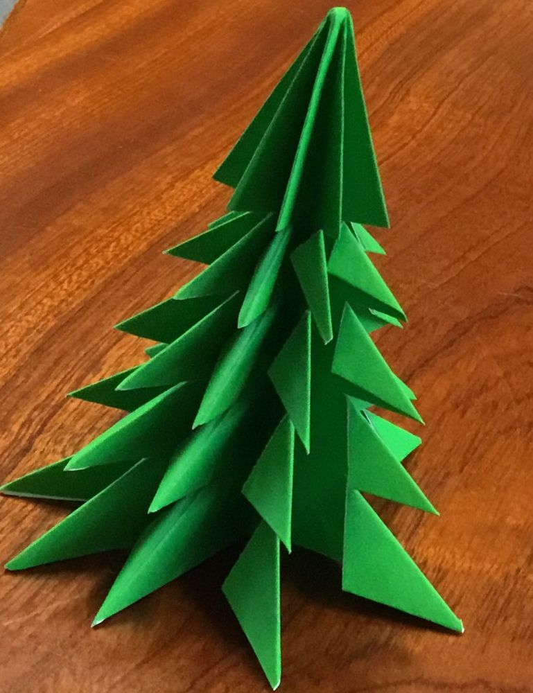 Christmas tree made of folded and cut green paper. This gives a 3D effect and the tree stands up on its own.