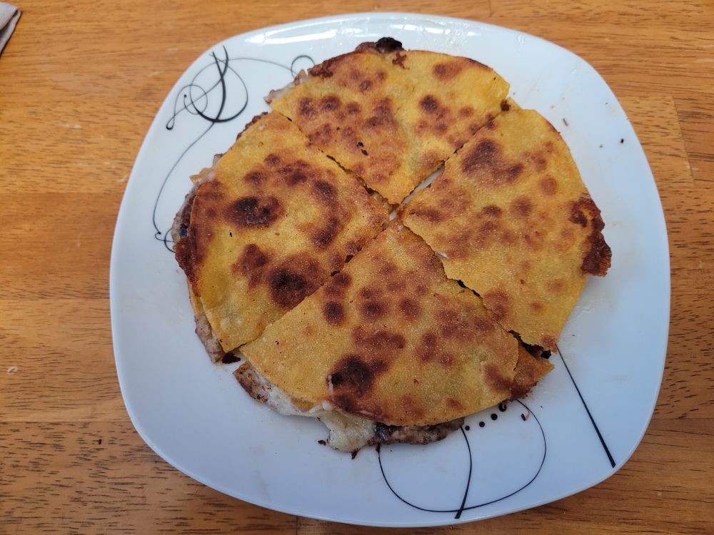 A chicken, black bean, and pineapple quesadilla on a plate. The original idea came from BudgetBytes, but I've definitely made it my own.