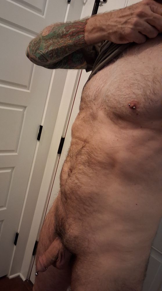 Man's hairy torso with pierced nipple and dick