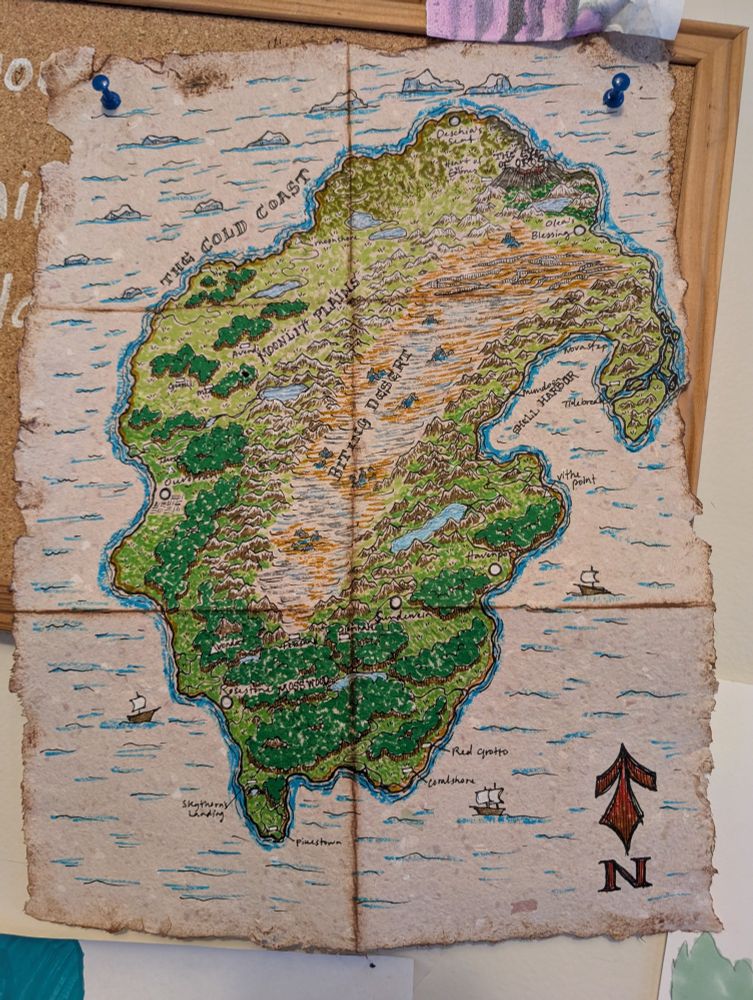 This continent is called Andula. Or, depending on who you ask, the continent is the physical embodiment of the goddess Andula. Regional religion is still an area of study and still being compiled as a continent-wide encyclopedia.
Drawn with fineliners on handmade paper, painted with watercolor brush pens, and given a distressed look with a brown ink pad. 
I have been giving this project a lot of loving attention, and I hope to write enough life within these shores to create a story worth telling to more people than just myself. 
