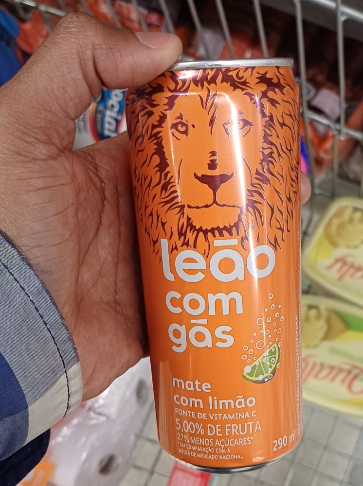 Lata laranja com o rosto de um leão de 290ml de Mate com limão gaseificada. 