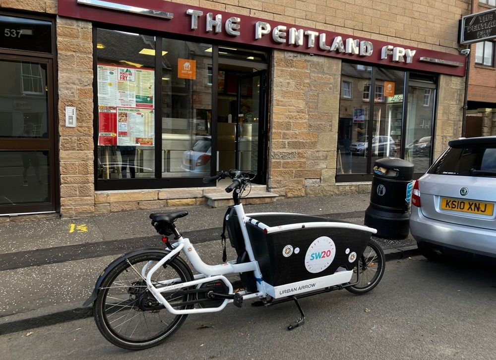 The SW20 free-to-hire community eCargobike outside the Pentland Fry, Juniper Green 