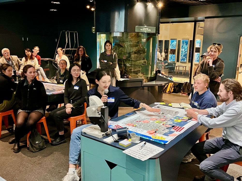 People sit around tables playing an educational game