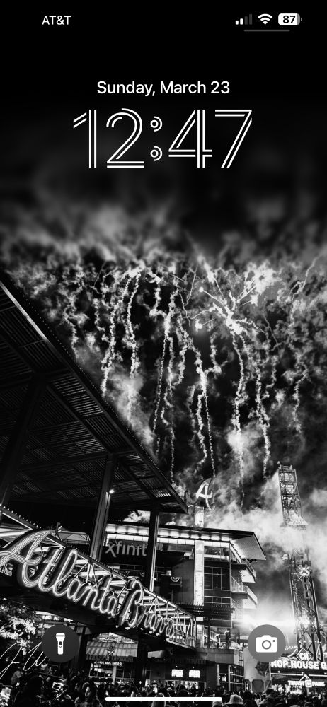 My phone lockscreen with a black and white filter of fireworks at Truist Park