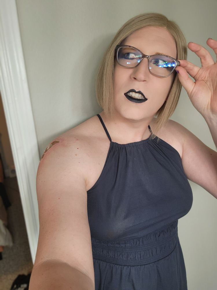 Rachel, a blonde woman, being silly and looking off to her right while pretending to put on her glasses.