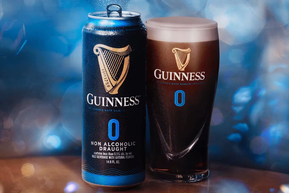 Guinness 0 can next to a Guinness 0 glass.