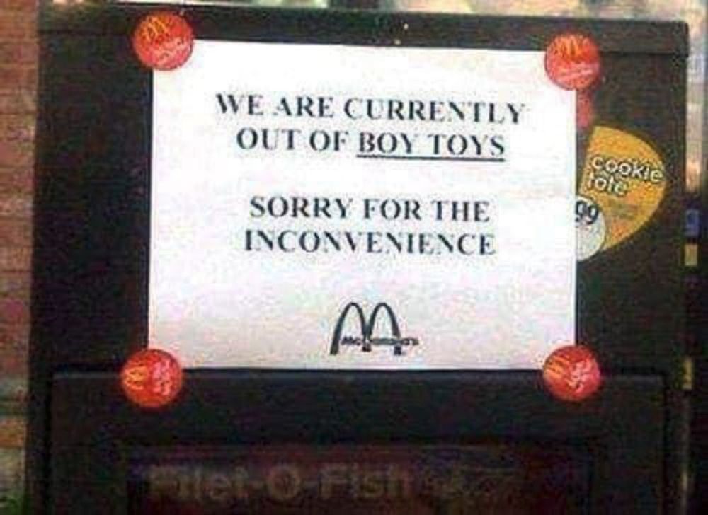 A sign posted over a McDonalds drive thru that says, "We are currently out of boy toys! Sorry for the inconvenience"