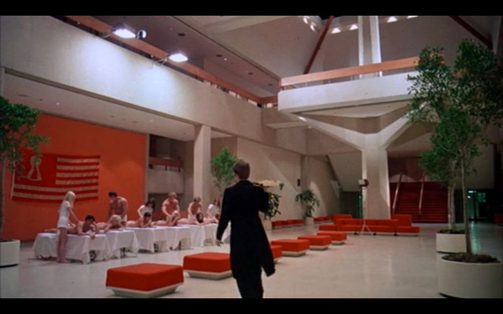 Interior of the Chet Holifield building, made up to be a totalitarian playland in Death Race 2000, open anodyne spaces with blood red upholstered furniture.