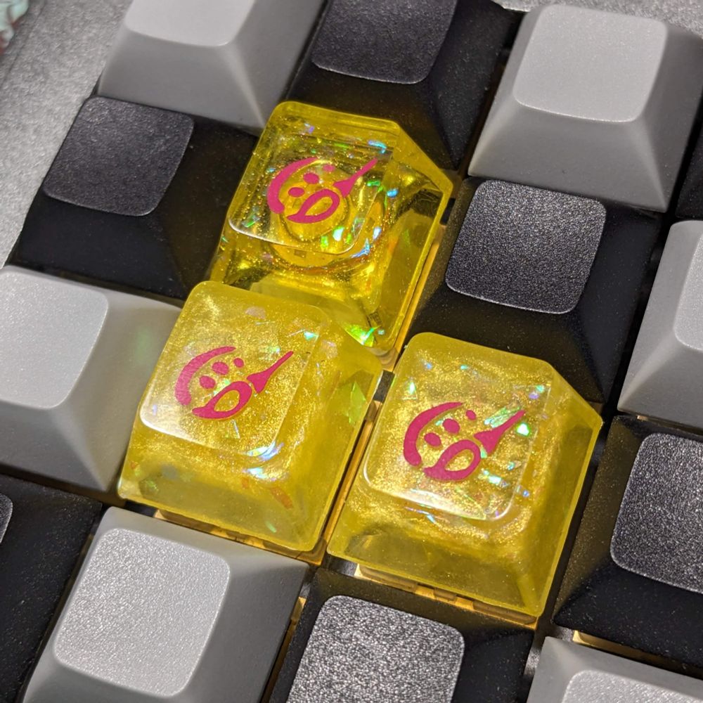 3 handmade resin keycaps that are designed to look like the Pictomancer job stone from FFXIV