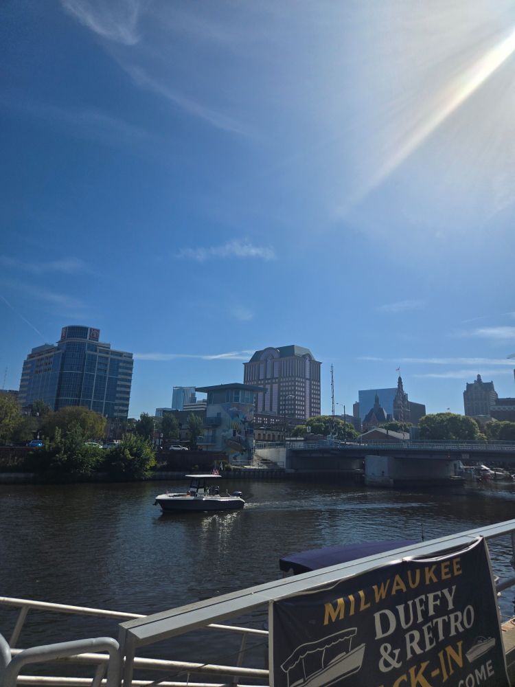 Small boat passing under the Juneau Ave bridge in Milwaukee WI. 