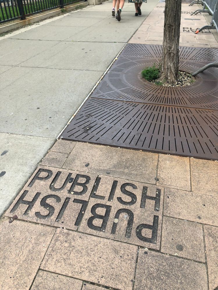 An engraved paving stone that says "publish." The word appears twice, in mirror image, so you can see it whether you're coming or going.