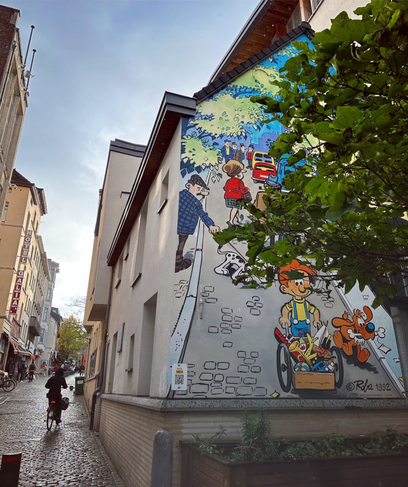 Boule et Bill descendant une rue pavée sur le mur d’une maison dans une rue pavée