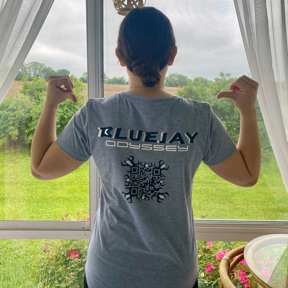 A woman models the back of a shirt with a QR code for the BlueJay Odyssey book series by Emilia Reeves