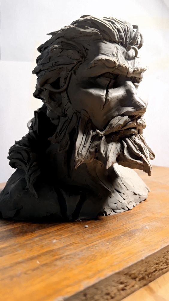 Bust made of plasticine
It depicts my character Quincy (from Sea of Thieves) 
 He has wavy hair tied in a ponytail, and large beard and mustache. He has a scar going through his right eye and many other big scars going through his body. The following photos are other angles of the same bust with different lighting 
