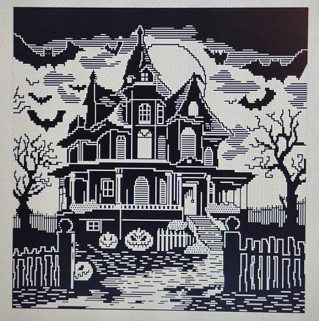 Mosaic yarn design of a Halloween themed house, with bats in the sky around, and pumpkins on the porch.