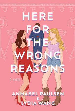 The cover of the book "Here for the Wrong Reasons" by Annabel Paulsen and Lydia Wang. The background is a bright pink and the illustration features two white women holding hands with a white man visible between them in the distance, with his back turned. There are shadowed suggestions of lights and cameras in the spaces around the characters.