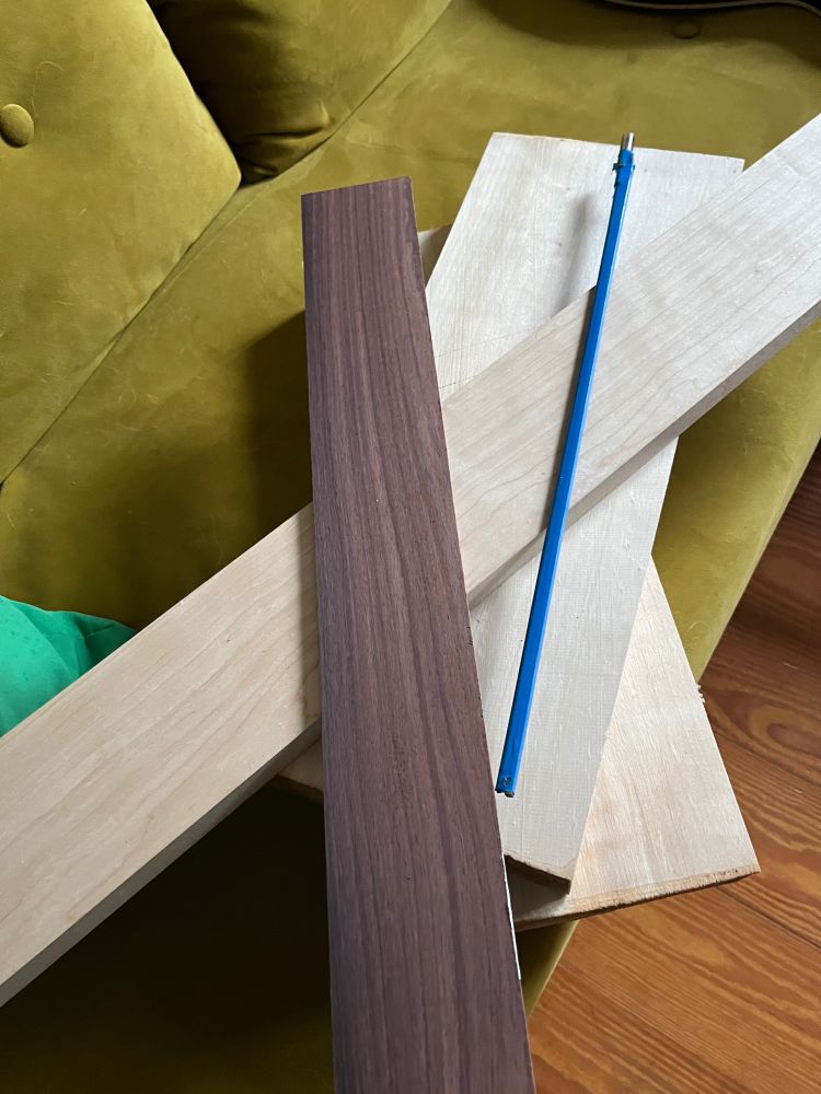 Some pieces of dark and fair wood, piled on a greenish velvet sofa.