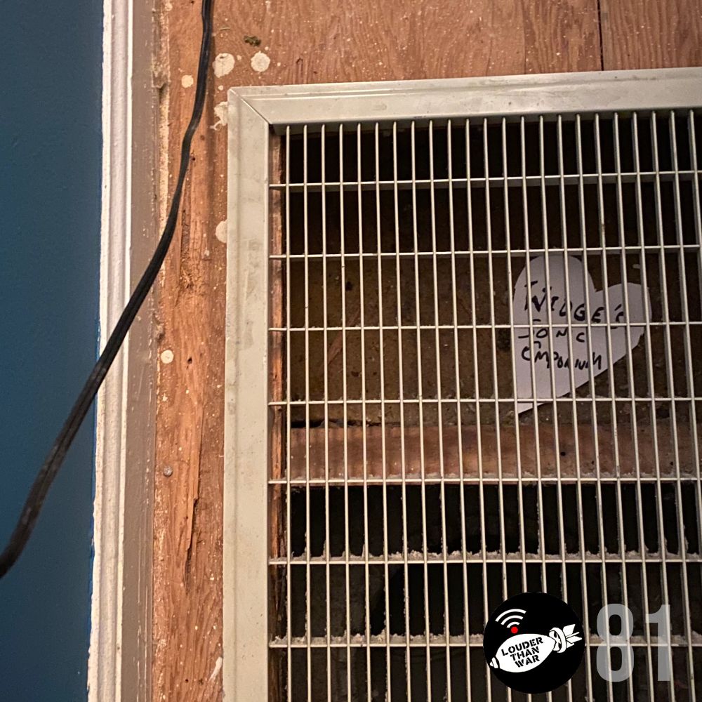 An electrical cable runs along the left side of the image. Most of it is taken up by an air vent, surrounded by bare wood floor. Behind the grill of the vent is a heart-shaped piece of paper that says WIDGE'S SONIC EMPORIUM on it, scrawled in black Sharpie. In the lower right hand corner, the Louder Than War Radio logo as well as 81, the number of the episode.