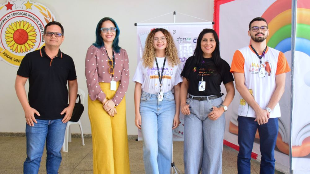 5 pessoas sorrindo, alinhadas. 