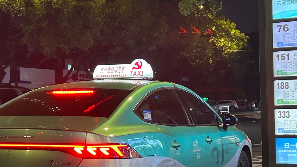 A Hangzhou taxi with a sign that reads 共产党员示范车. (Communist party demonstration car)(?). That's what google translate says. 