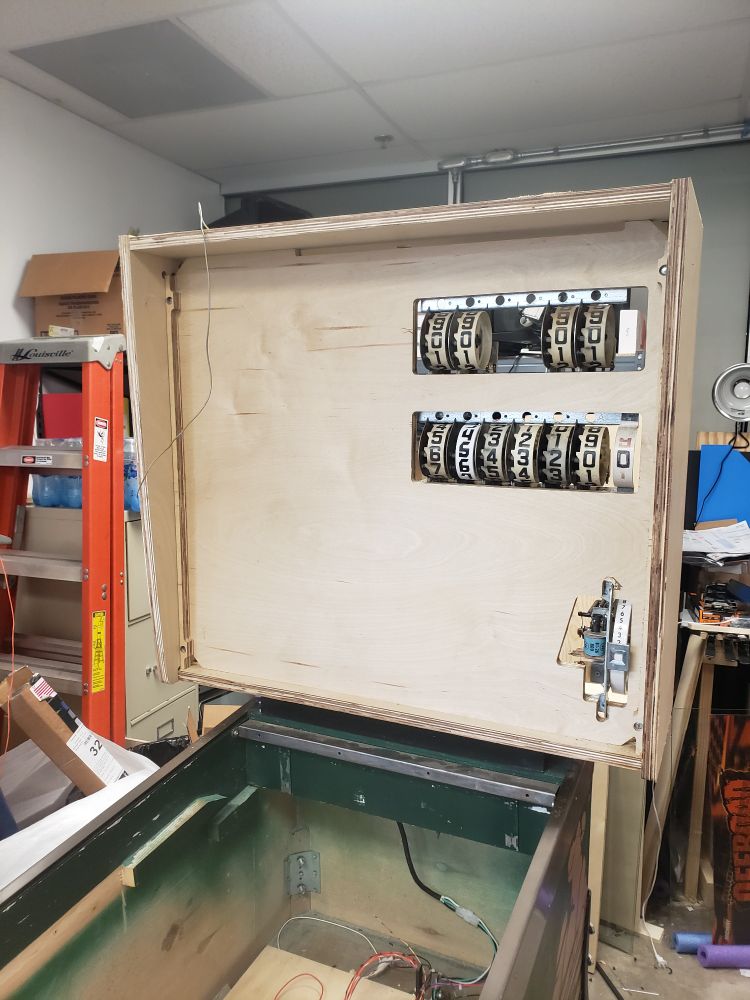 The front view of a homebrew electromechanical pinball machine's head. Here the player 1 (top) and player 2 (bottom) score reels can be seen, and below them is the credit reel.
