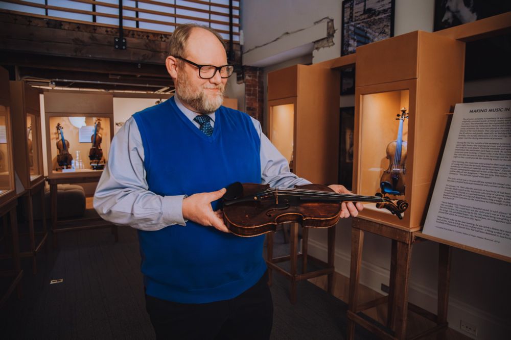 James A. Grymes holding Motele Schlein's Violin