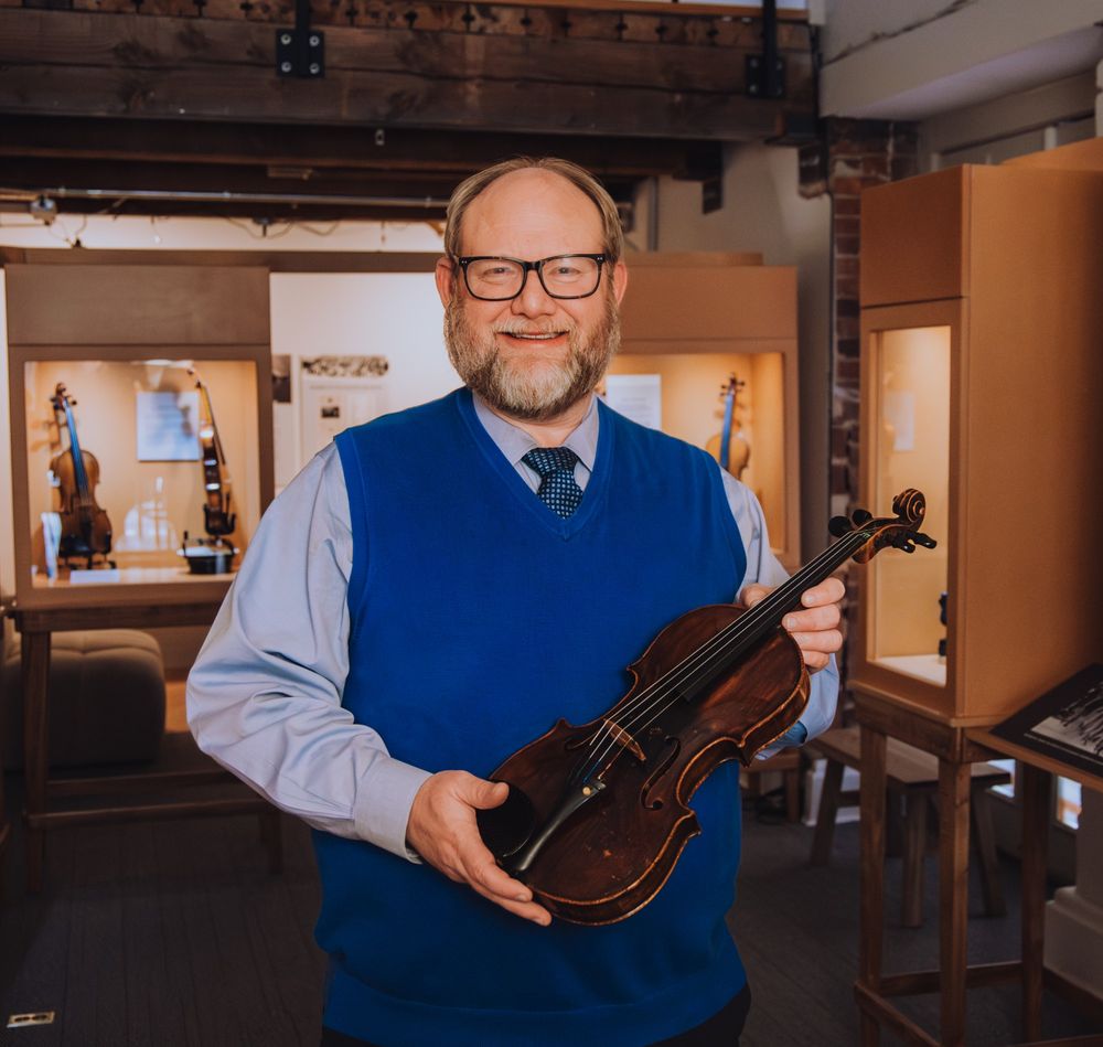 James A. Grymes holding Motele Schlein's Violin