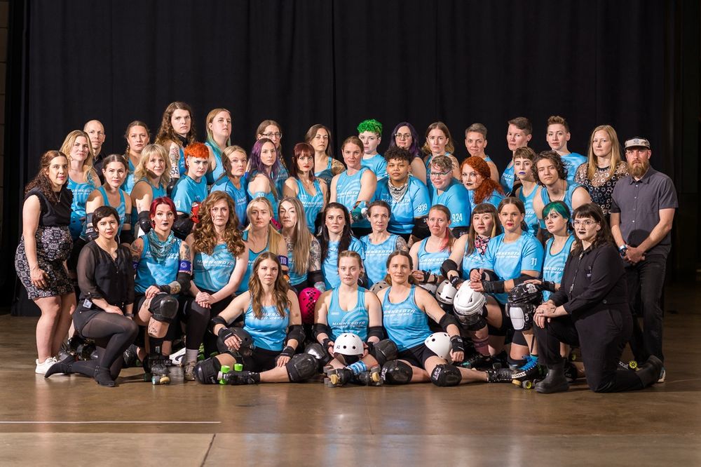 A photo of Minnesota Roller Derby’s all star program. The skaters are in blue jerseys and the coaches are in black. 