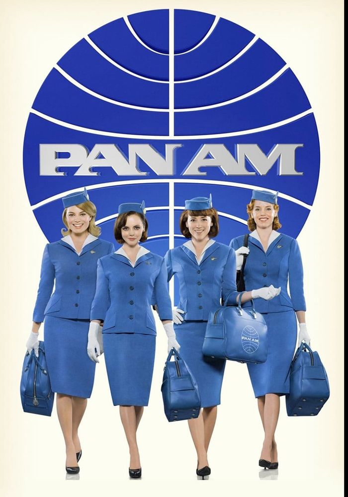 Women in blue stewardess uniforms in front of Pan Am logo