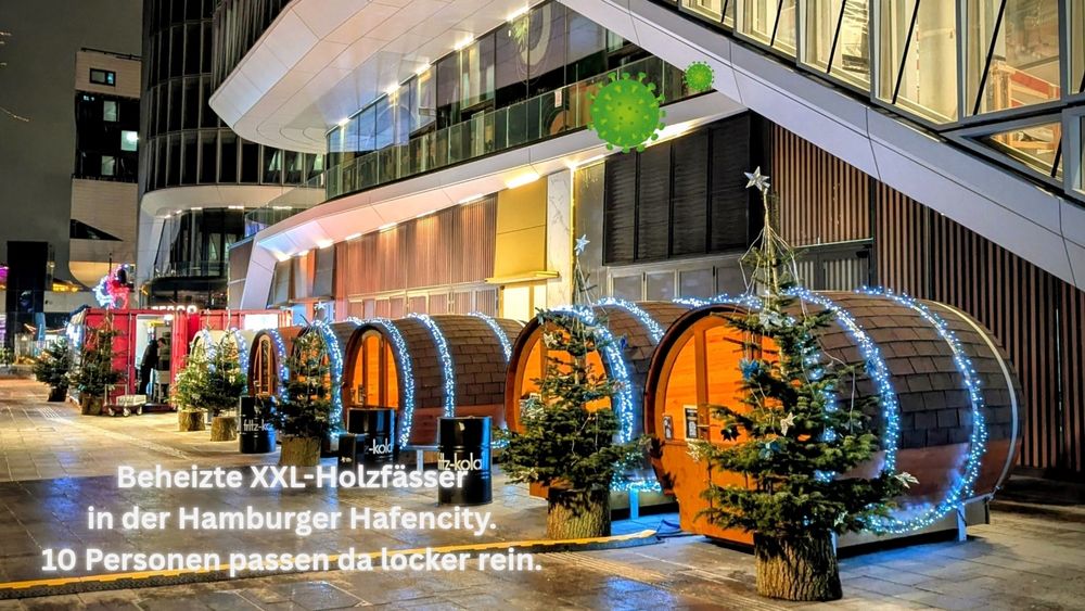 Große Holzfässer am Einkaufszentrum Westfield (Hafencity). Die Fässer sind weihnachtlich dekoriert und beleuchtet. Davor stehen kleine Weihnachtsbäume.

Text: Beheizte XXL-Holzfässer in der Hamburger Hafencity. 10 Personen passen da locker rein. 