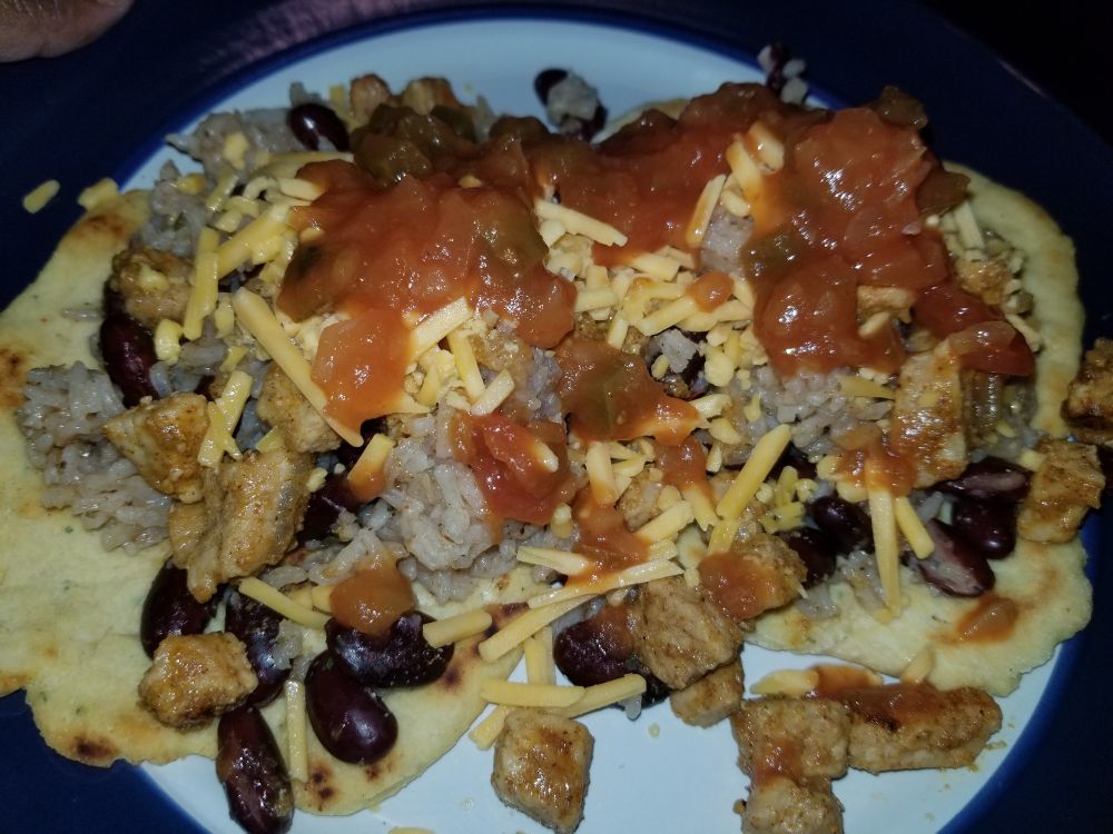 Pork, rice, beans, cheese, and salsa dish.