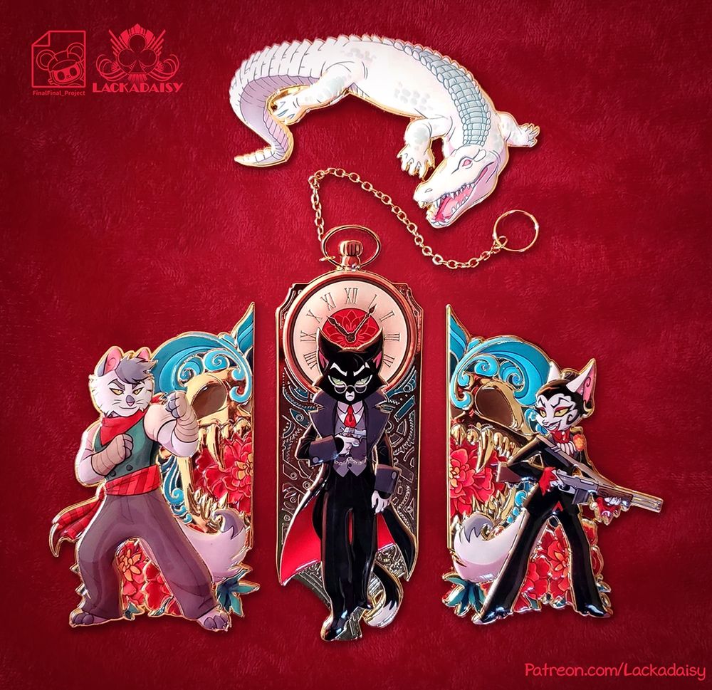 A photo of the Marigold jumbo pin set, featuring the Lackadaisy characters Nicodeme, Mordecai, and Serafine. The gator LeBlanc is also included.