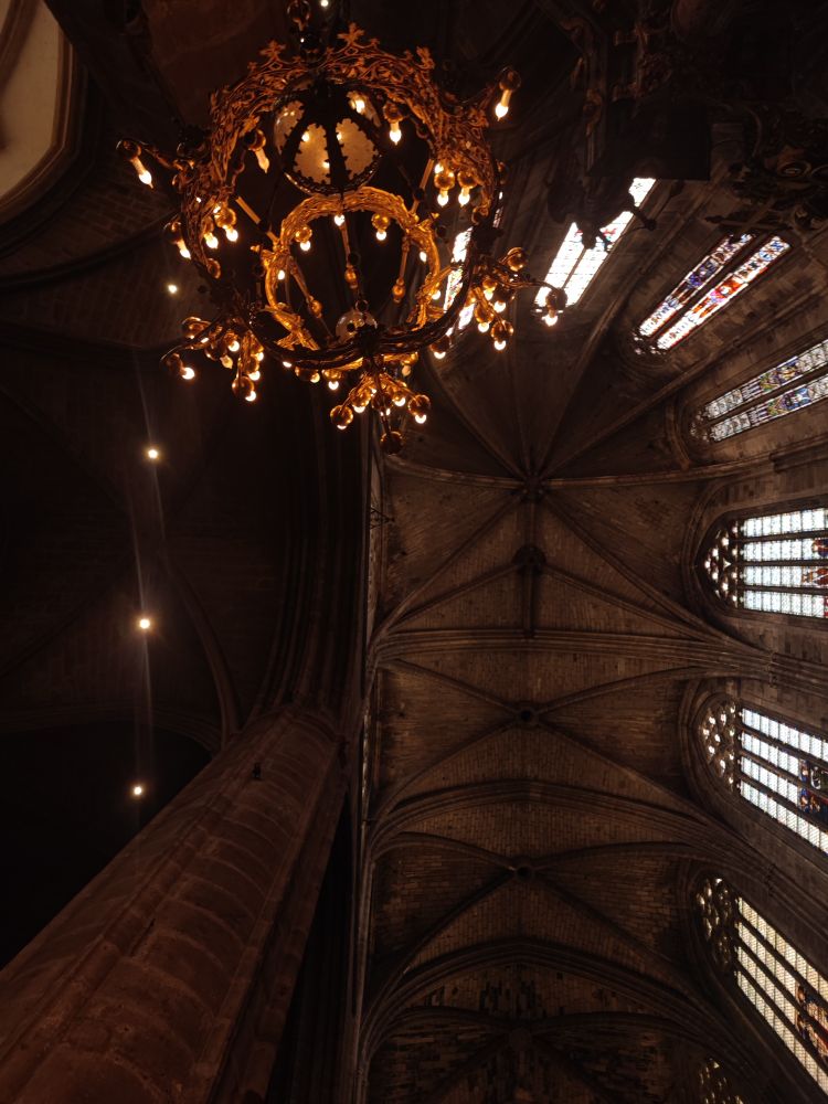 Vue sur les voûtes, un lustre suspendu et un gros pilier de la cathédrale 