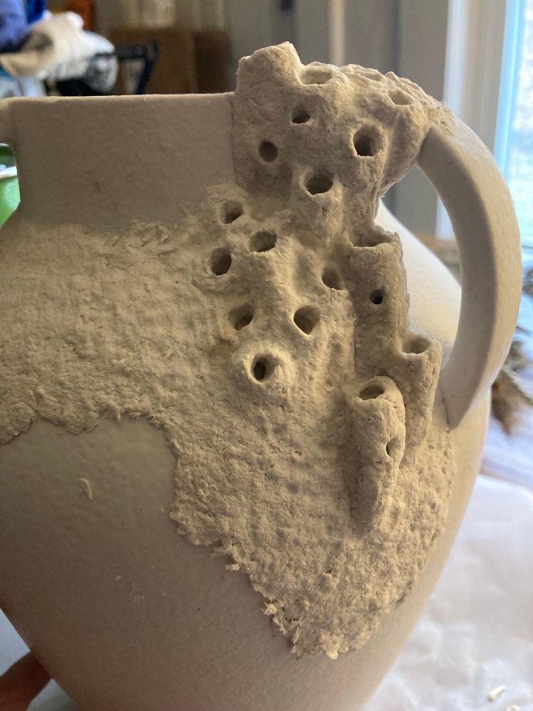 a vase with papier mache wasp nests 