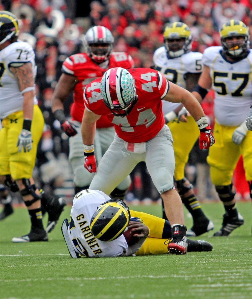 An Ohio State player standing over a sacked quarterback