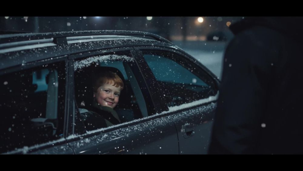 screenshot du spot TV Sport 2000. Un garçon, assis à l'arrière d'une voiture, regarde quelqu'un à travers la vitre enneigée.