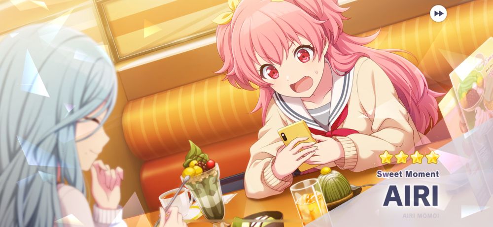 Screenshot of a gatcha pull in the game Project Sekai. The card art displayed is of the character Airi Momoi sat at a cafe booth with various cafe treats looking at her phone with a shocked face. Her friend is sat off to the left giggling at Airi’s display of shock. 