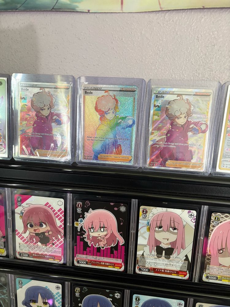 picture of Pokémon trading cards of the character Bede on top of a frame of bocchi the rock trading cards. 